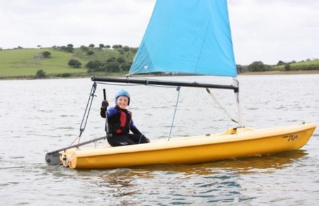 Sailing at Sibblyback Child sailing a boat on the lake